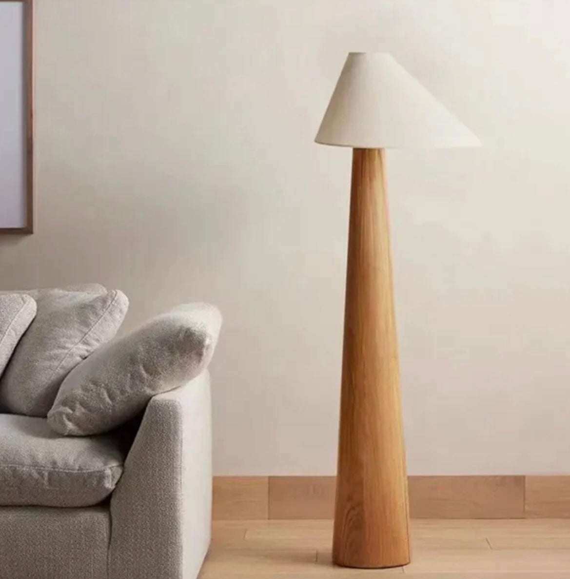 Wabi-sabi solid wood floor lamp with conical base and beige lampshade in minimalist living room setting