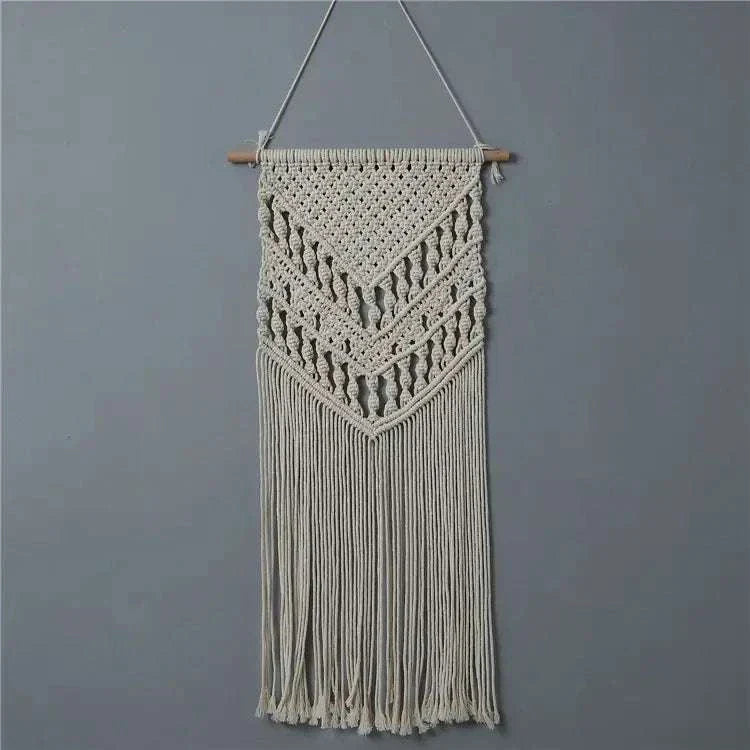 Bohemian-style woven tapestry wall hanging with intricate patterns and fringes on wooden pole