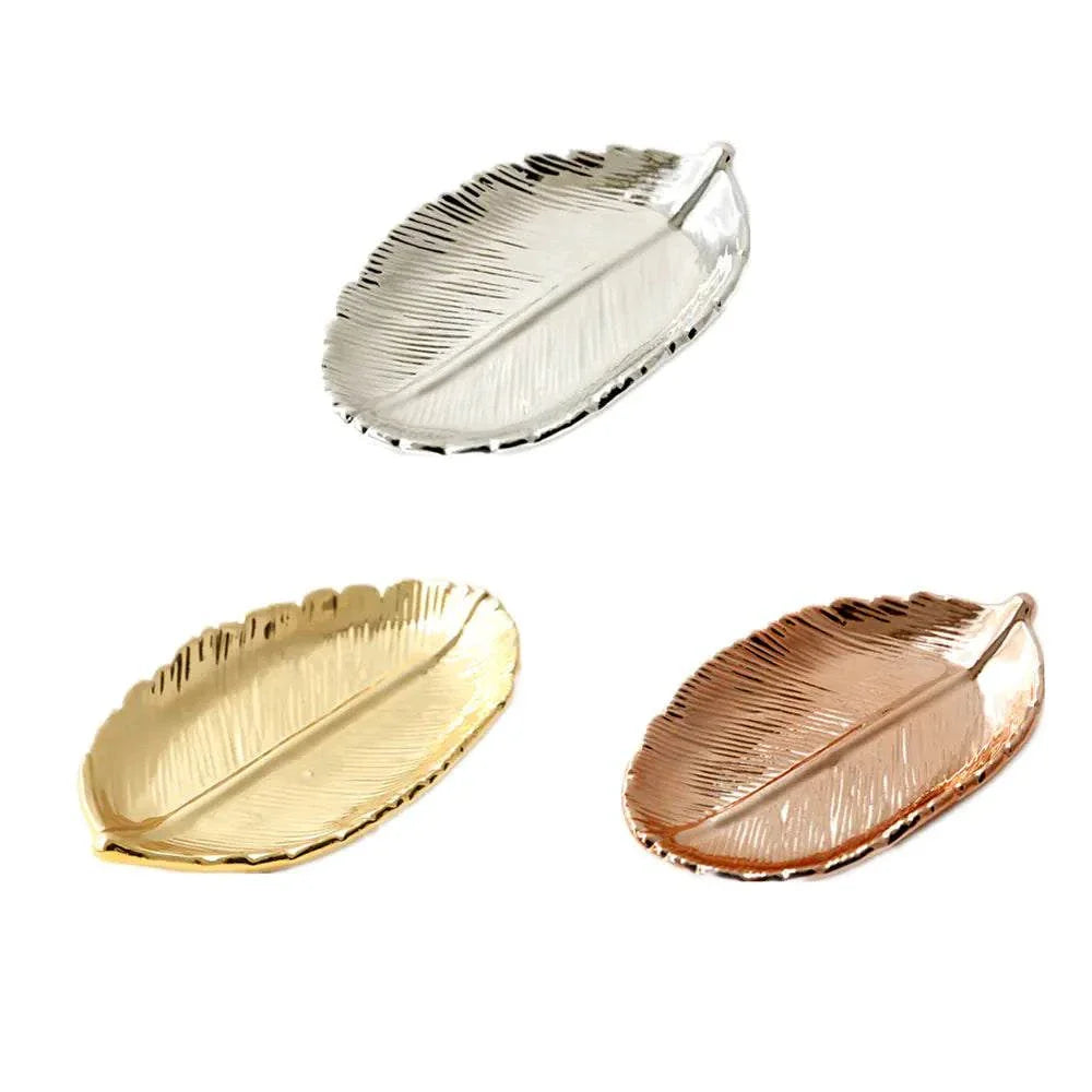 Three ceramic jewelry trays shaped like leaves with gold, silver, and rose gold electroplated finishes.