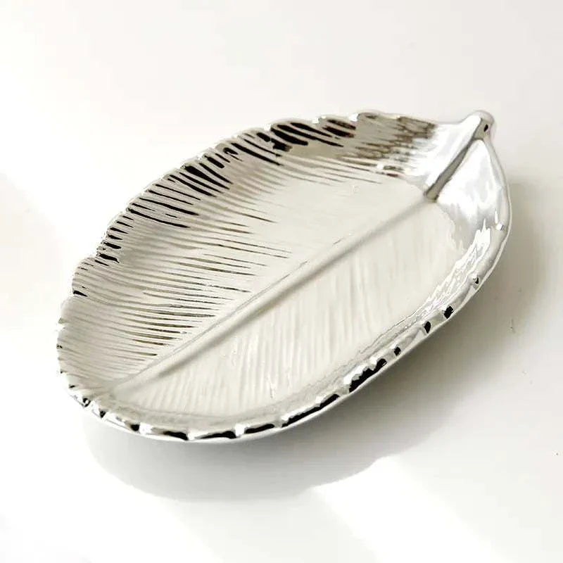 Silver ceramic jewelry tray shaped like a leaf with gold electroplated finish