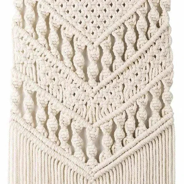 Bohemian-style woven tapestry wall hanging with intricate cotton patterns and fringes in neutral white