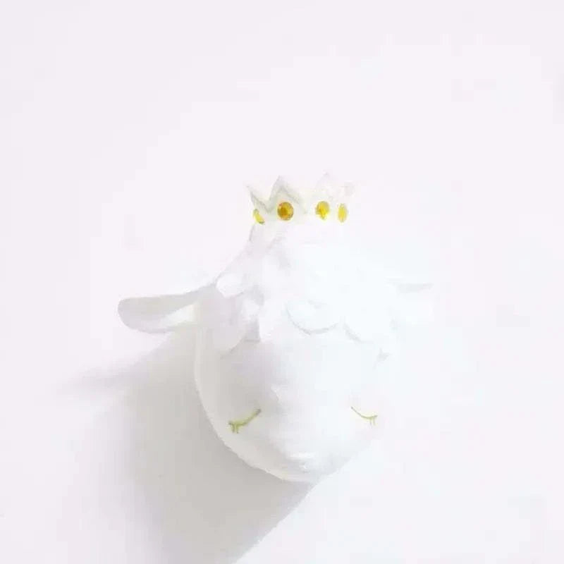 White decorative plush wall hanging shaped like a sleeping sheep with a golden crown.