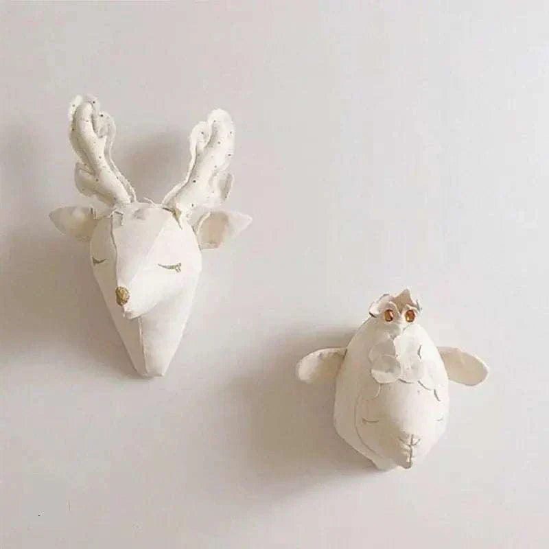 Set of decorative plush wall hangings featuring a white deer head and a white sheep mounted on a wall