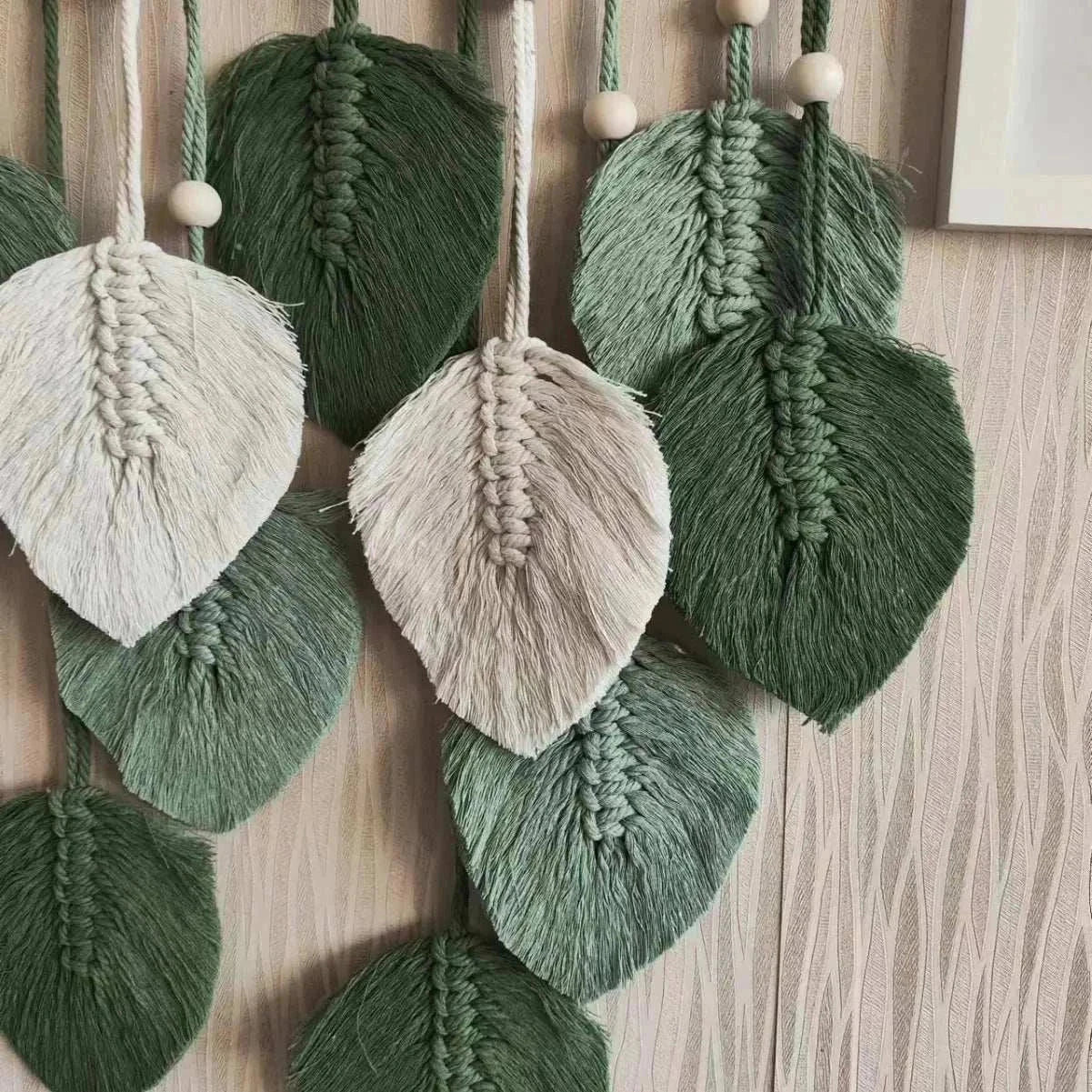 Handmade woven tapestry featuring bohemian leaf-shaped cotton fringes in green and white shades for wall decor