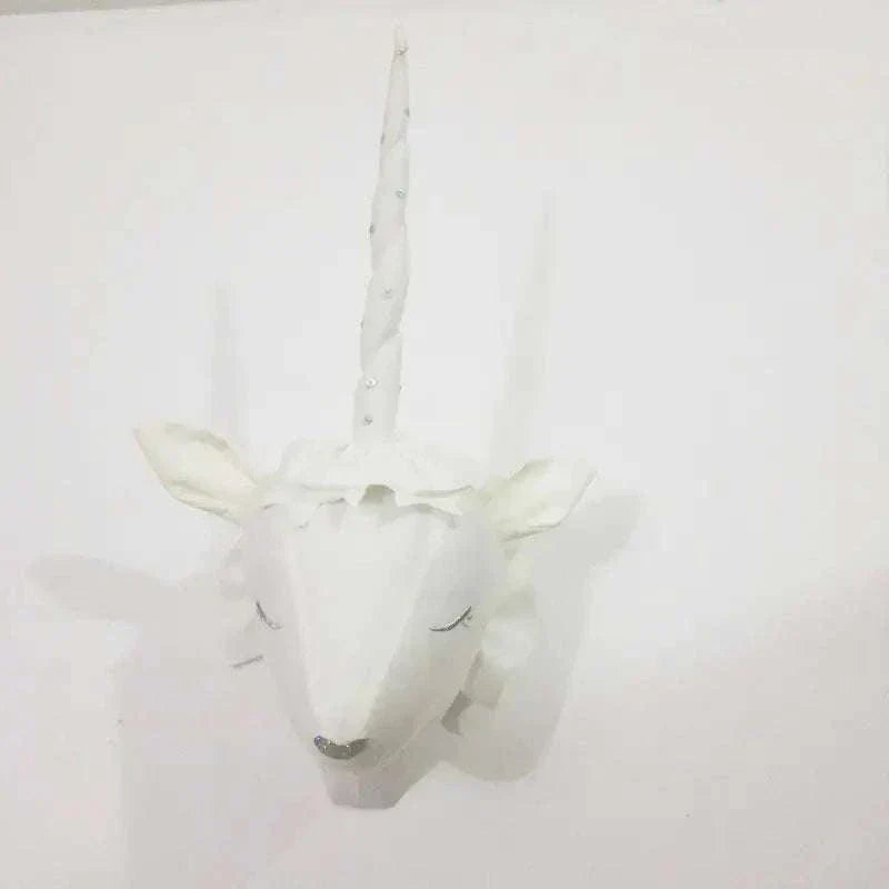 white decorative plush wall hanging unicorn head with long horn and closed eyes on white wall