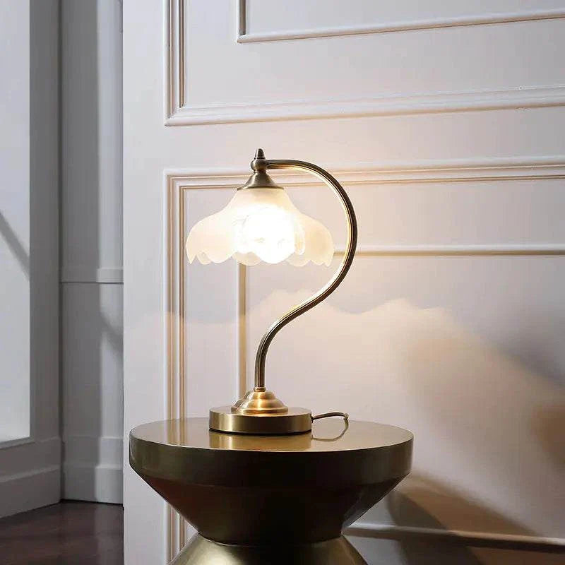 American-style copper decorative table lamp with glass shade and gold finish on round table by wall