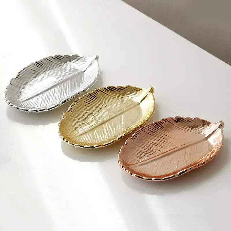 Set of three ceramic jewelry trays with gold leaf design in silver, gold, and rose gold finishes